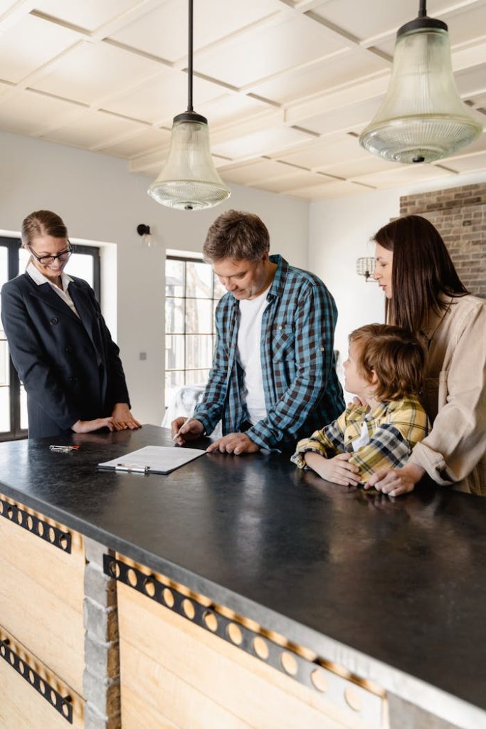 pexels-photo-7415115 Family with a child signing a real estate agreement in a bright, modern kitchen with a realtor.